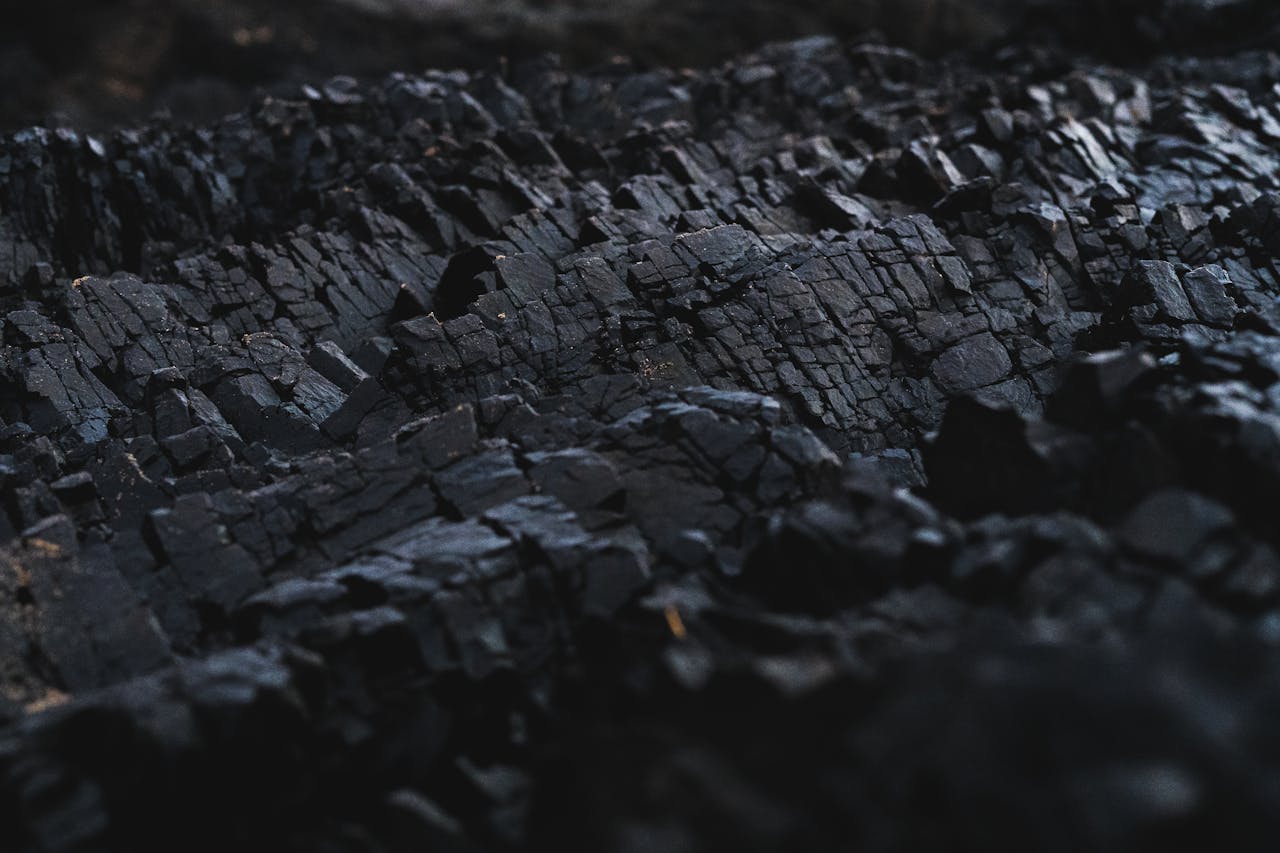 A detailed close-up of dark charcoal texture, showcasing its rough and jagged surface.